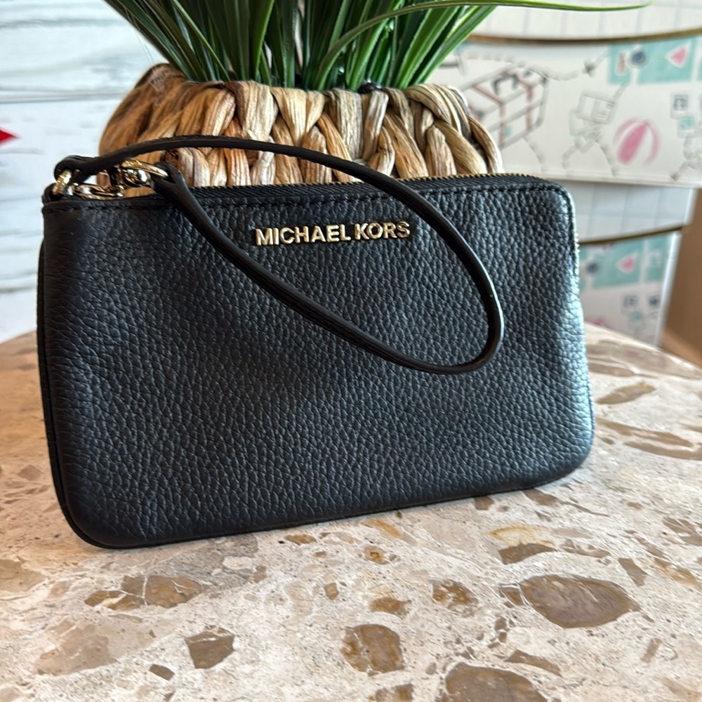 Michael Kors black pebble wristlet with attached handle/zipper.